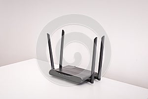 black wifi router on white table indoors