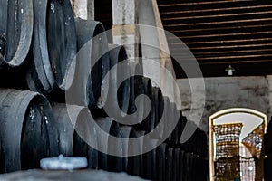 Black wine barrels with wine in winery photo
