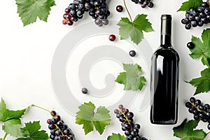 Black wine bottle with fresh red and green grapes on white background, creating vibrant contrast.