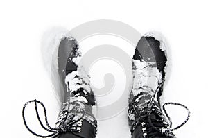 Black winter boots on the snow, top view