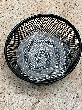 Black wire bowl of sliver paper clips top view