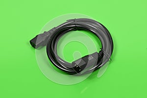 Black wire C13 female and C14 male connector power plug, isolated on green