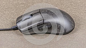 Black wired computer mouse on gray surface with textured design