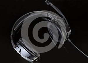 Black wired headset with full size headphones on dark surface