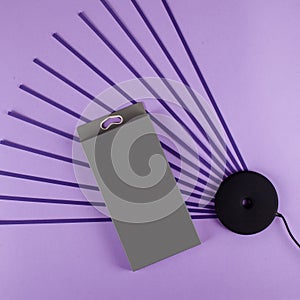 Black wireless charger for mobile phone on purple background with sripes