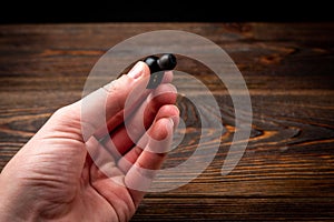 Black wireless headphones and mobile phone on dark wooden background