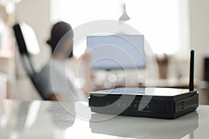 Black wireless router on white reflective table