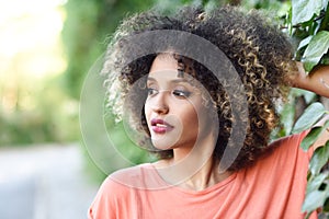 Black woman with afro hairstyle standing in an urban park