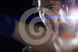 Black woman, athlete and boxing punch with arm on dark background for night training, earphones or sweat. Female person