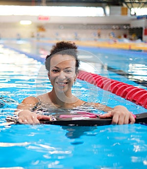 Black woman attending water aerobics class in a swimming pool