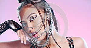 Black woman, bdsm portrait and chain mask with metal, rock or punk aesthetic by pink background. Gen z model, sexy and
