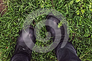 Black woman boots on green grass photo