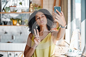 Black woman, cafe and selfie with peace sign, hands and relax for social media, app or profile picture. Young gen z girl