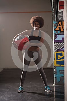 Black woman carrying crossfit ball