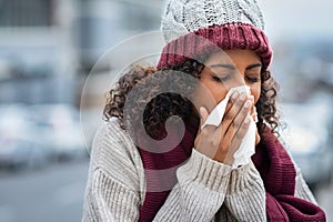 Black woman with cold sneezing outdoor