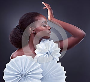Black woman, cosmetics and origami fans in studio, makeup and oriental profile on dark background. Female person, skin