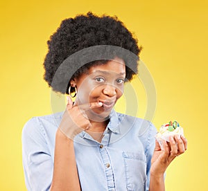 Black woman, cupcake and studio portrait for smile, temptation or cheat with junk food by yellow background. African