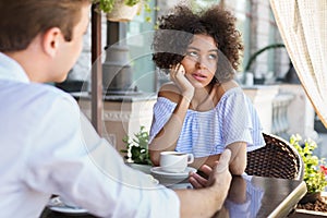 Black woman disinterested with blind date outdoors