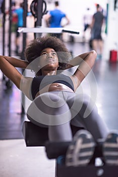 Black woman doing sit ups at the gym