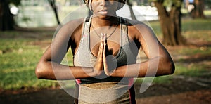 A black woman doing yoga in a park