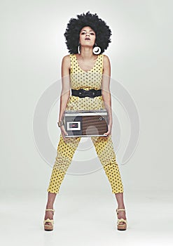 Black woman, fashion in studio with radio in jumpsuit, white background, afro and vintage. Colour, attitude and trendy