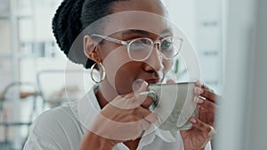 Black woman with glasses in office drink tea at computer, smile while reading email or feedback report. Businesswoman