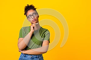 Black woman in glasses thinking about question, touching chin