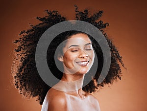 Black woman, hair care and natural afro, smile and beauty against brown studio background. Happy young african american