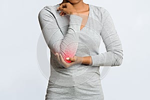 Black woman having acute pain in elbow joint