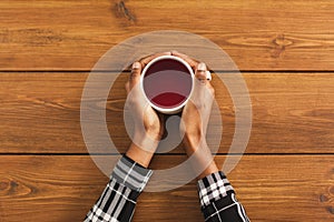 Black woman holding coffee cup, top view