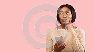 Black Woman Holding Mobile Phone Thinking Standing In Studio, Panorama