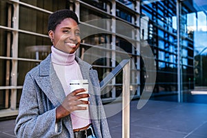 Black woman with hot drink in downtown