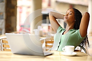 Black woman with laptop resting in a restaurant