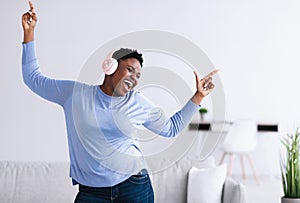 Black woman listening to music in headphones and dancing