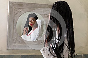 Black woman looking in mirror