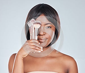 Black woman, makeup brush and cover eye in studio with change, beauty and foundation by background. Girl, person and