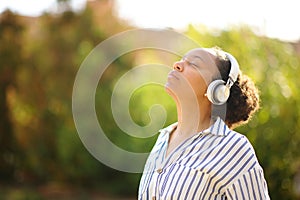 Black woman meditating using headphone