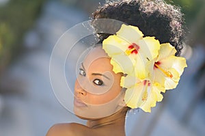 Black woman, model of fashion, with big flowers in her hair