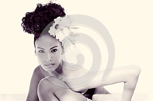 Black woman, model of fashion, with big flowers in her hair