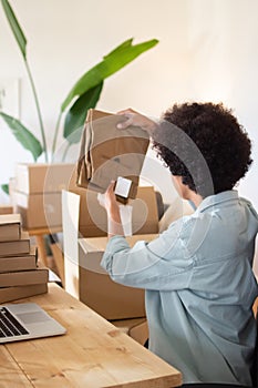 Black woman packing pants into box