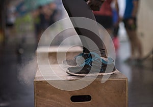 Black woman is performing box jumps at gym