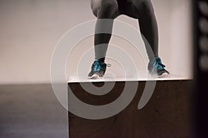 Black woman is performing box jumps at gym