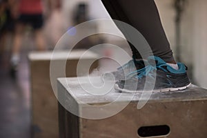 Black woman is performing box jumps at gym