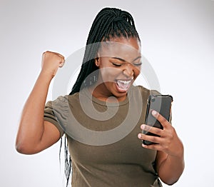 Black woman, phone and victory for winning, discount or sale against a grey studio background. Happy African American