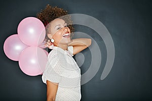 Black woman, portrait and balloons in studio for fun, personality and celebration on black background. Face, balloon and