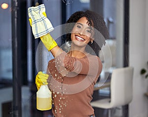 Black woman, portrait and cleaning windows in home, wipe glass and spray chemicals for hygiene. Female person, maid and