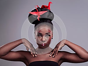 Black woman, portrait and origami bird in studio isolated on gray background with makeup for aesthetic. Cosmetics