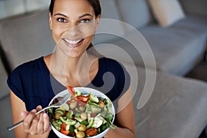 Black woman, portrait and salad for food, eating and diet on sofa, couch and lounge. Vegan lady, happy female person and