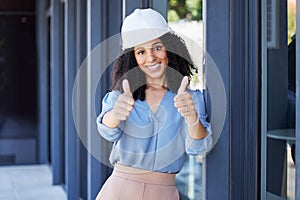 Black woman, portrait smile and thumbs up for construction, building or good job with hard hat for on site work safety