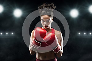 Black woman professional boxer standing in pose, ready to fight